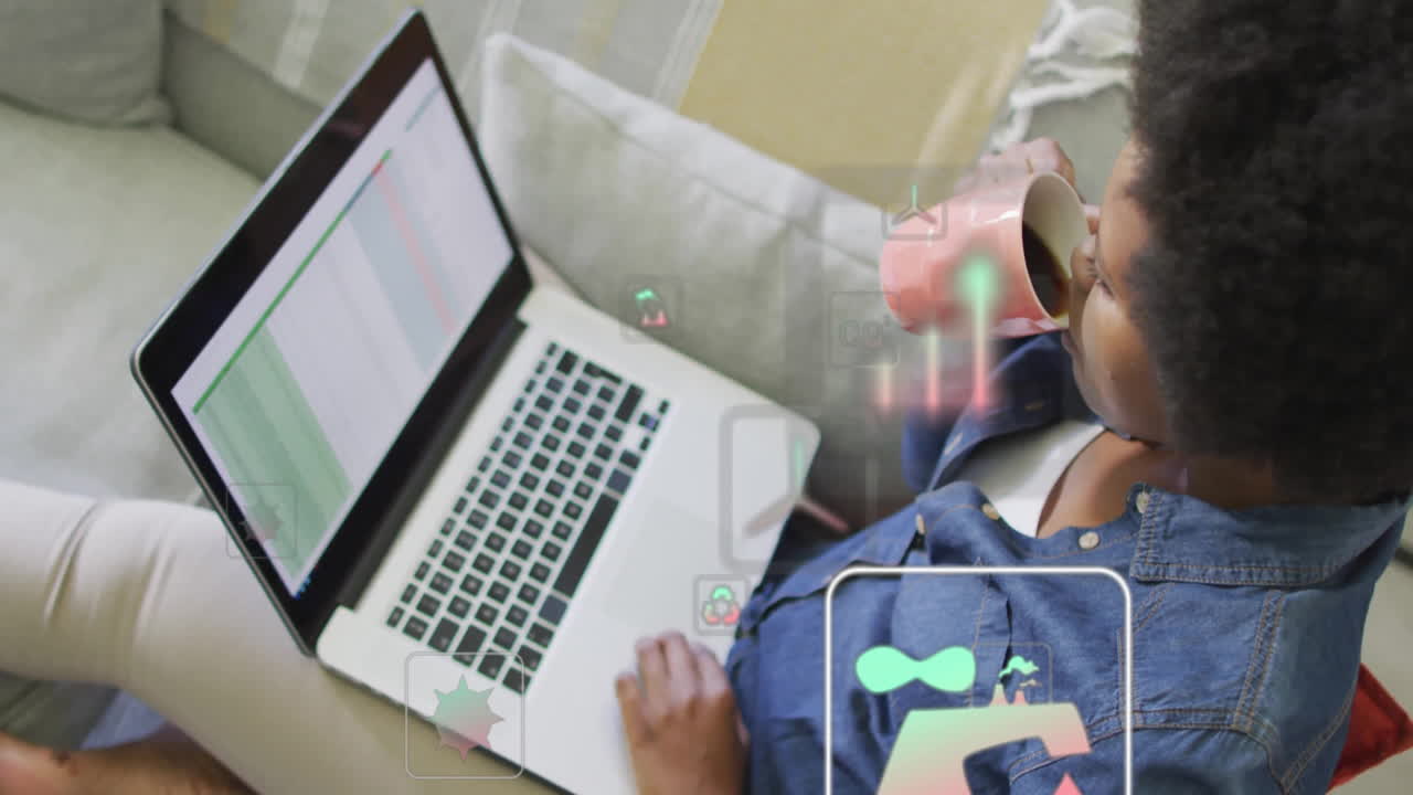Animation of media icons and data processing over biracial woman using laptop
