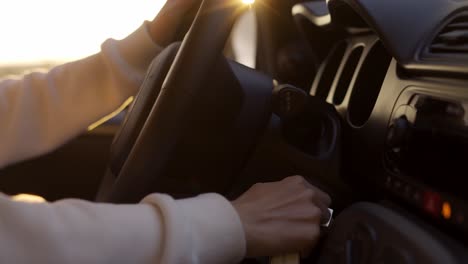 Mujer-Rubia-Arrancando-El-Coche-En-La-Costa-Durante-La-Hora-Dorada