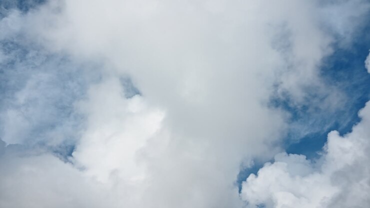 Snowy mountain peaks touched by clouds in a dramatic aerial shot