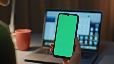 fingers scrolling chroma key smartphone at evening home close up. unknown woman