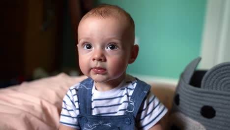 Close-up-of-6-month-old-baby-boy-playing,-laughing,-and-smiling-in-nursery