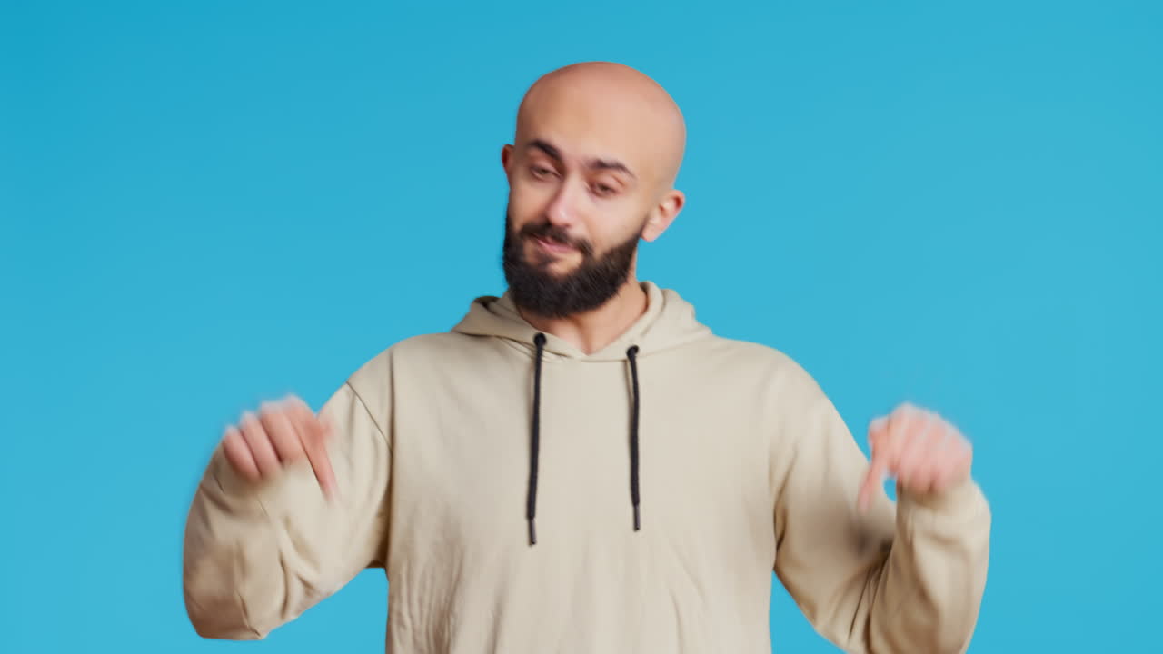 un tipo de oriente medio apuntando hacia abajo para mostrar algo.