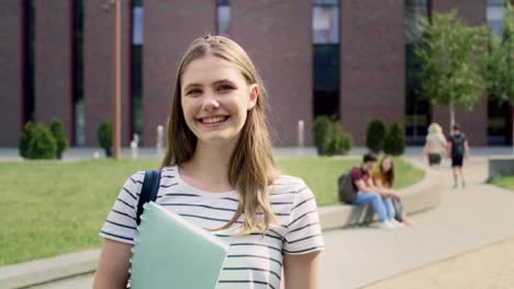 portrait of female university student standing outside the university campus