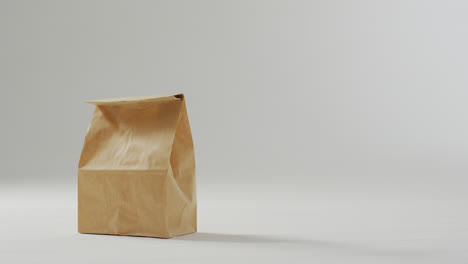 animation of paper lunch bags on white background