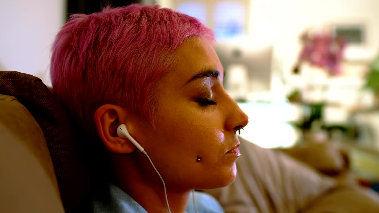 거실 4k에서 헤드폰으로 음악을 듣는 여자