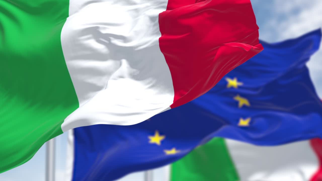 바람에 흔들리는 이탈리아 국기와 배경에 흐릿한 유럽 연합 발의 끊임없는 느린 동작 루프