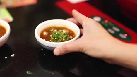 hand stirring sauce in a small bowl