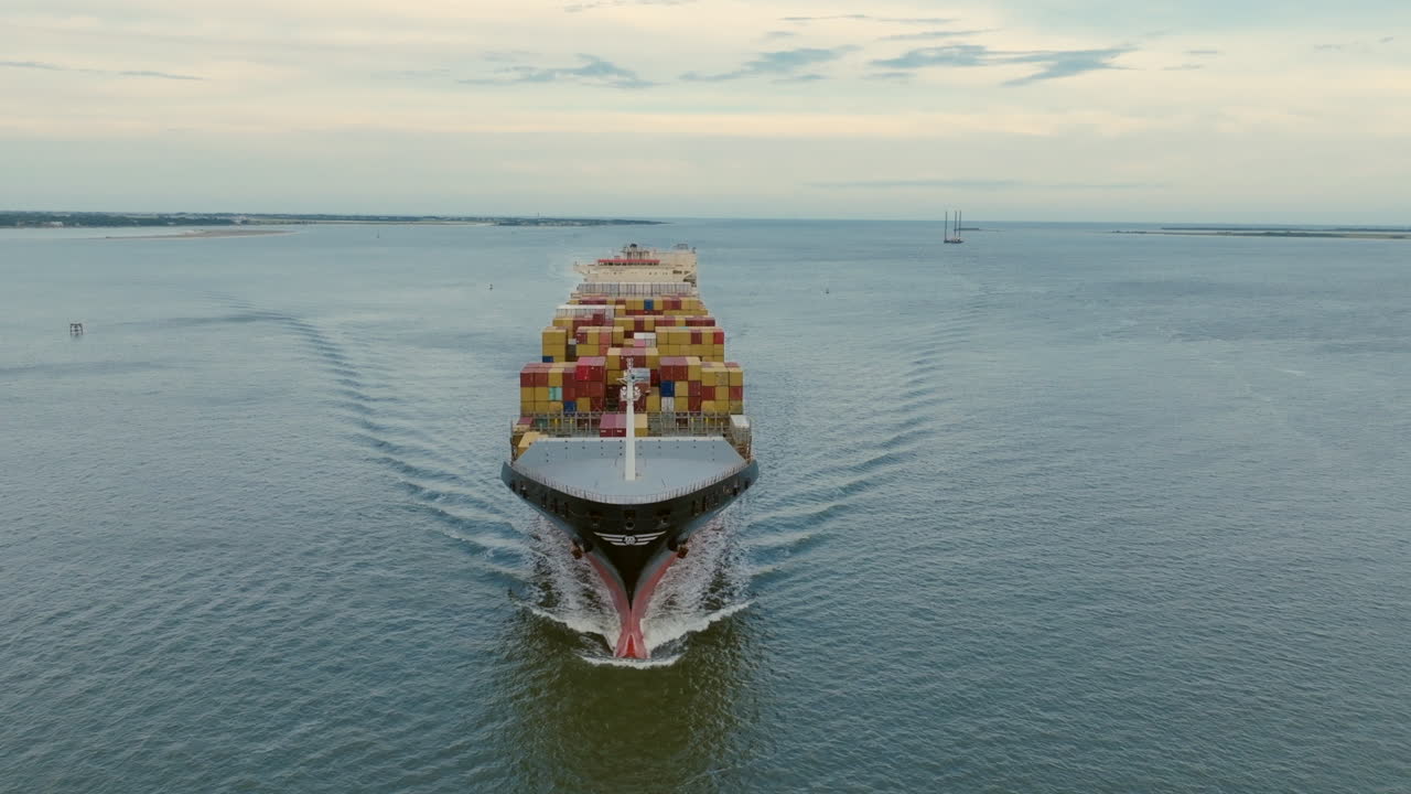 Large container ship loaded with cargo sailing on the water