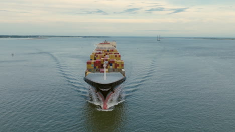 large container ship loaded with cargo sailing on the water