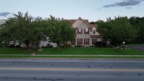 aerial view of classic pennsylvania architecture, with charming residential home. stone and siding, surrounded by lush greenery. suburban tranquility and community spirit in american suburb town.