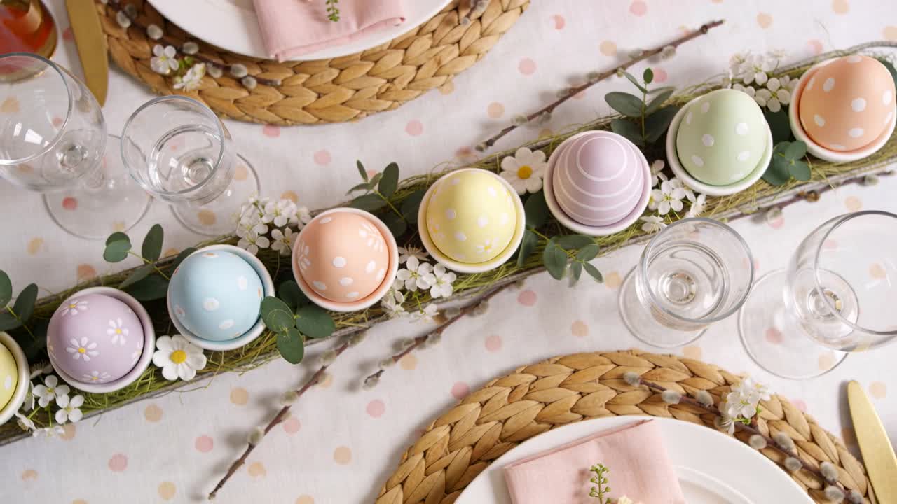Sliding camera revealing dining table at home, showcasing trough of pastel eggs, moss, pink napkins