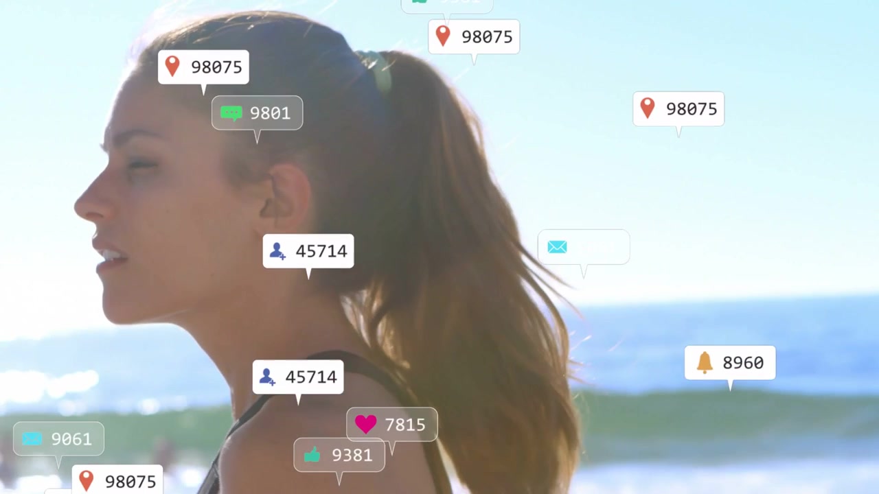 Woman entering shoreline, turning head and creating floating social icons around her for marketing