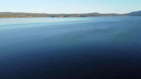 Static-aerial-clip-of-rippes-on-the-serene-Iskar-reservoir-near-Sofia,-Bulgaria-towards-the-Balkans-in-the-background