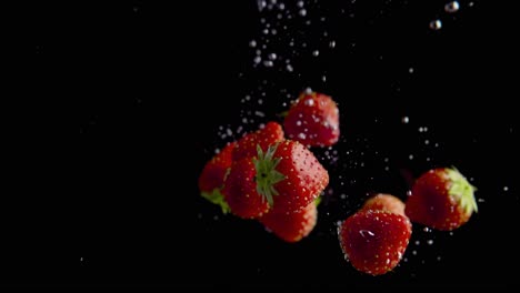 strawberries falling into water super slowmotion, black background, lots of air bubbles, 4k240fps