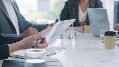 .4k video footage of a group of businesspeople using a digital tablet and going through paperwork during a meeting in an office