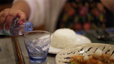 water poured into glass beside thai meal