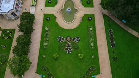drone flying over thabor gardens with fountains and flower beds, rennes in france. aerial top-down forward