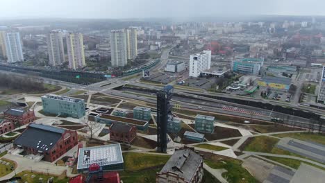 aerial flying over modern buildings of old mine and highway katowice 4k