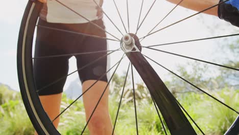 Senior-cyclist-repairing-bicycle-on-a-road-4k