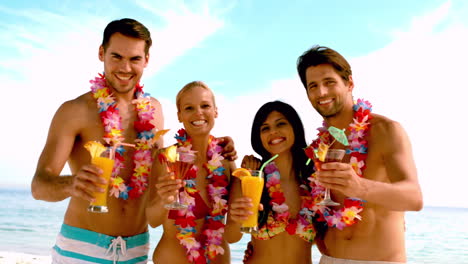 friends wearing garlands and enjoying cocktails on the beach