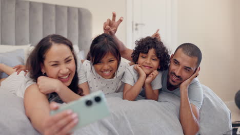 Parents,-kids-and-selfie-on-bed