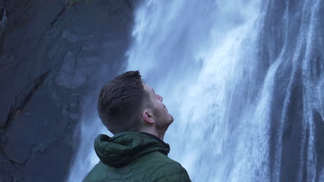 Männlicher-Wanderer,-Der-In-Zeitlupe-Zum-Wasserfall-Blickt