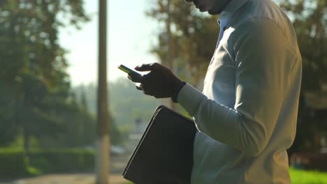hombre usando teléfono inteligente al aire libre