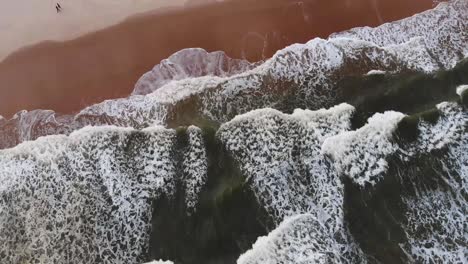 drone over breaking waves green sea