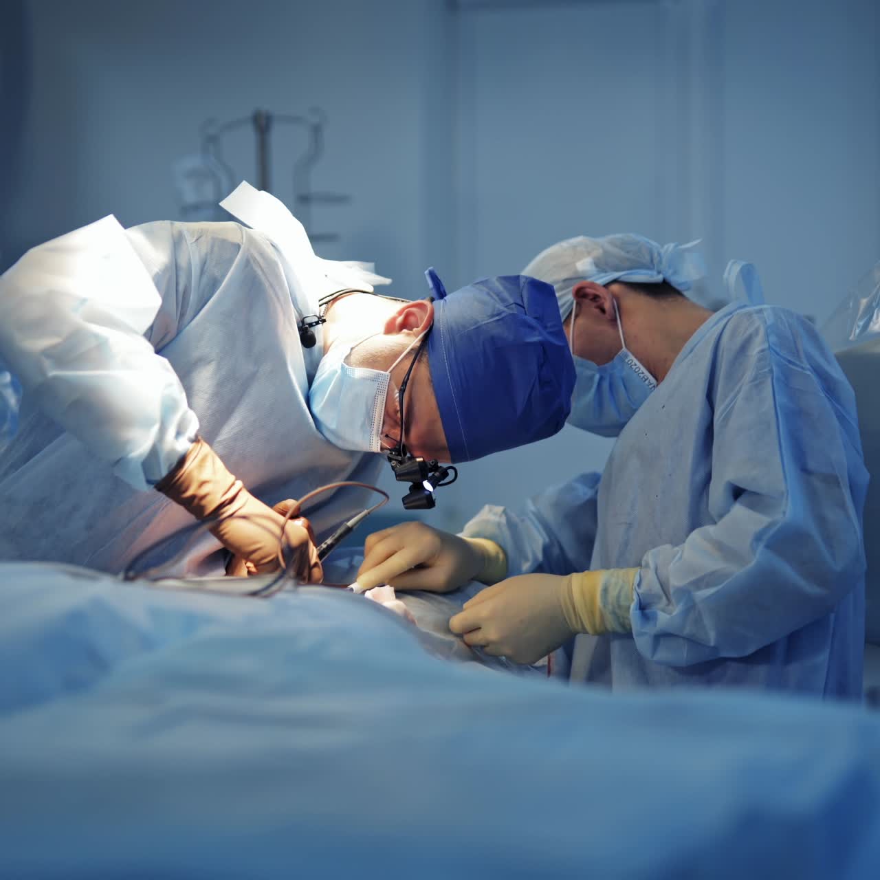Neurosurgeon and assistant in the operating room. Professional doctors in medical uniform performing a surgery to patient. Neurosurgery concept.