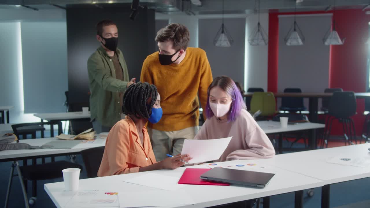 los estudiantes están entrando en el aula para el seminario, saludándose y sonriendo, mientras que uno de los estudiantes está dando a su profesor algunas preguntas sobre la tarea