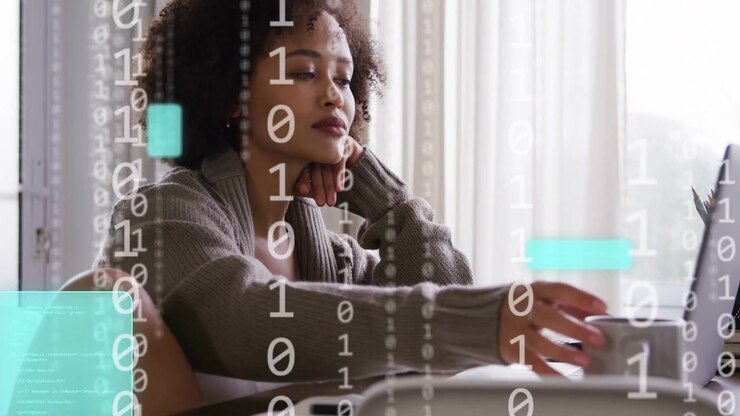Woman tapping laptop causing animated, binary, teal UI overlays, picking mug while working in tech