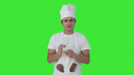 Confused-Indian-professional-chef-noting-down-recipe-Green-screen