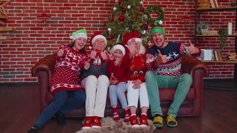 familia multigeneracional tomando una foto selfie en un teléfono móvil con temporizador en una casa decorada para navidad