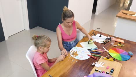 madre e hija haciendo artes y artesanías en casa