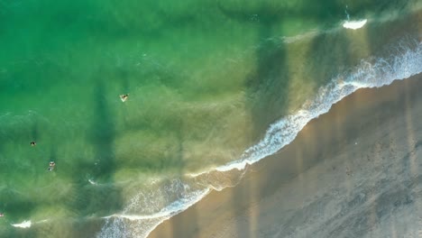 vista de drones de la playa de nha trang con playa turquesa, olas, arena y sombras de palmeras - ciudad de nha trang, provincia de khanh hoa, vietnam central