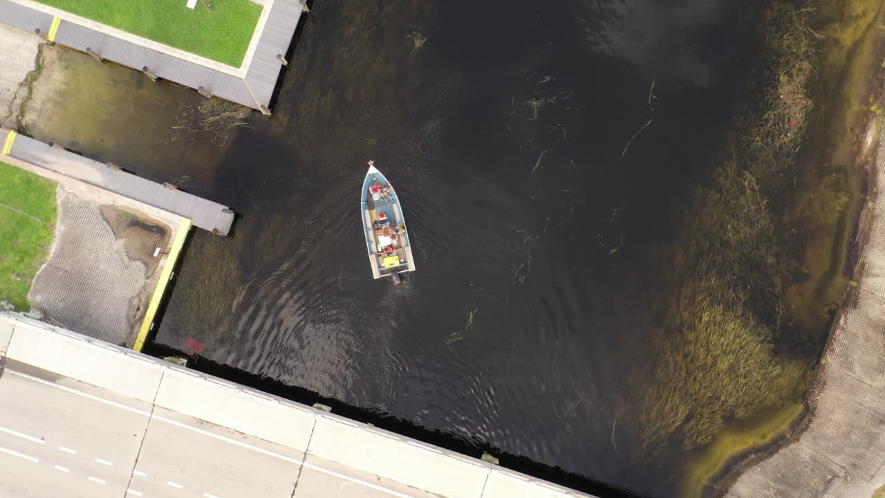una toma de arriba hacia abajo sobre un bote en un canal en un día nublado