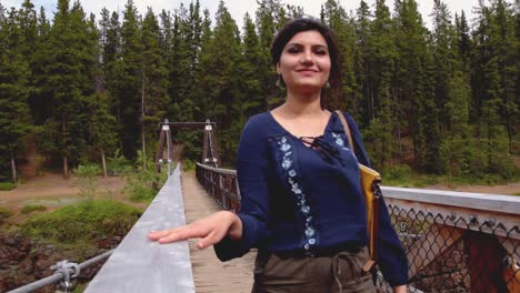 Indian-woman-walks-over-bridge-at-Miles-Canyon,-medium-shot