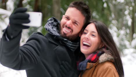 Pareja-Hablando-Y-Tomándose-Un-Selfie-Con-Teléfono-Móvil-En-Un-Día-De-Invierno