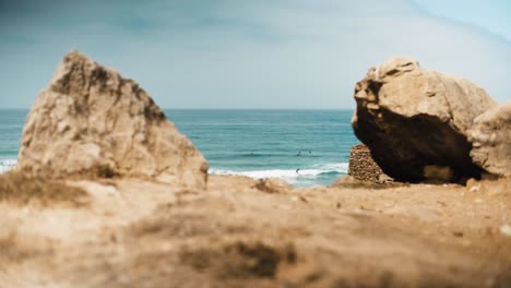 포르투갈의 guincho 해변은 바위 절벽 사이의 파도에 서퍼와 함께