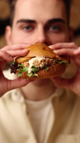 hombre comiendo una deliciosa hamburguesa de pollo