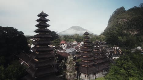 Drone-Vuela-Sobre-Kintamani-Bali-Isla-Indonesia-Pueblo-Revelando-El-Monte-Batur-En-Un-Paisaje-Brumoso-Místico-Escénico-Con-Templo-Hindú-Para-Ceremonia-Religiosa