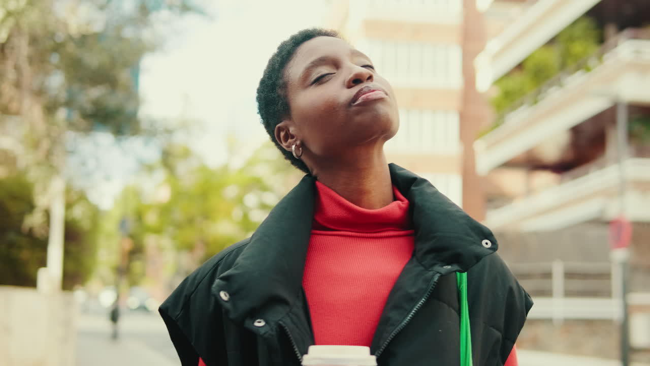 Young African American Woman Enjoying Sun and Coffee on City Street