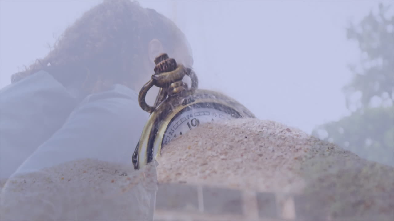 Partially buried in sand, antique pocket watch with blurred background