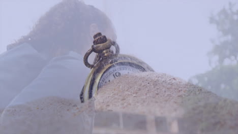 partially buried in sand, antique pocket watch with blurred background