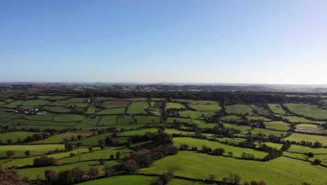 Vista-Aérea-En-Movimiento-Hacia-Adelante-De-Los-Campos-Verdes-De-La-Campiña-De-East-Devon,-Inglaterra