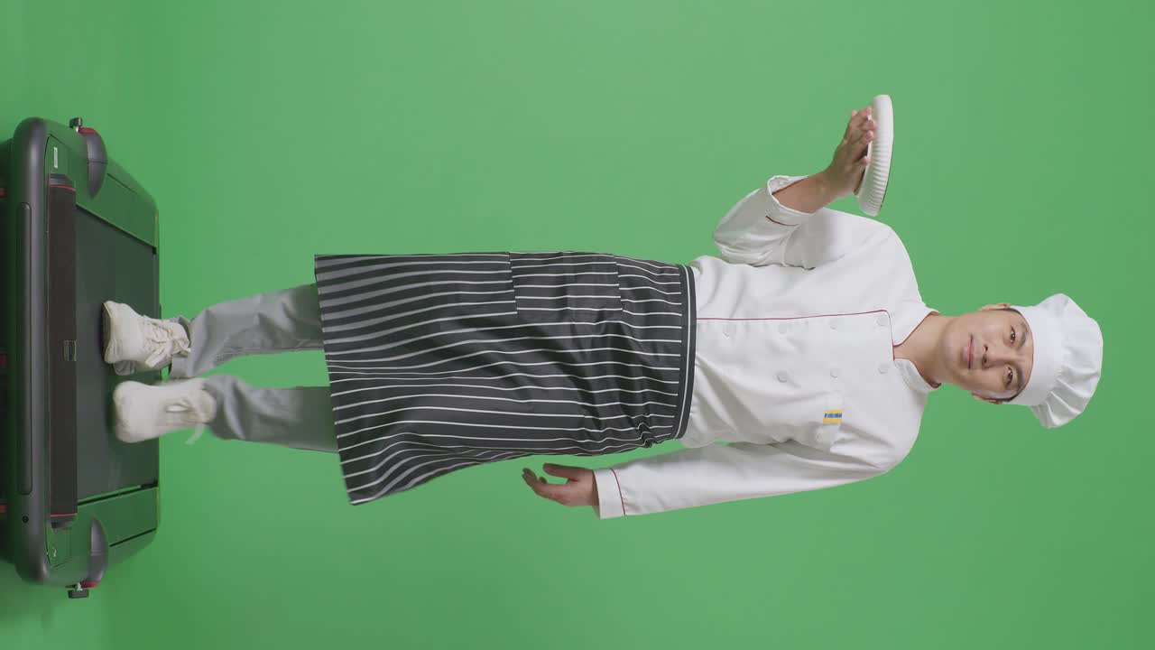 녹색 스크린 배경 스튜디오에서 트레드밀을 는 동안 접시를 들고 있는 아시아 남자 셰프의 전체 몸