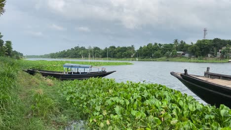 beautiful landscape of rural bengal with river, forest and two boats in a cloudy day