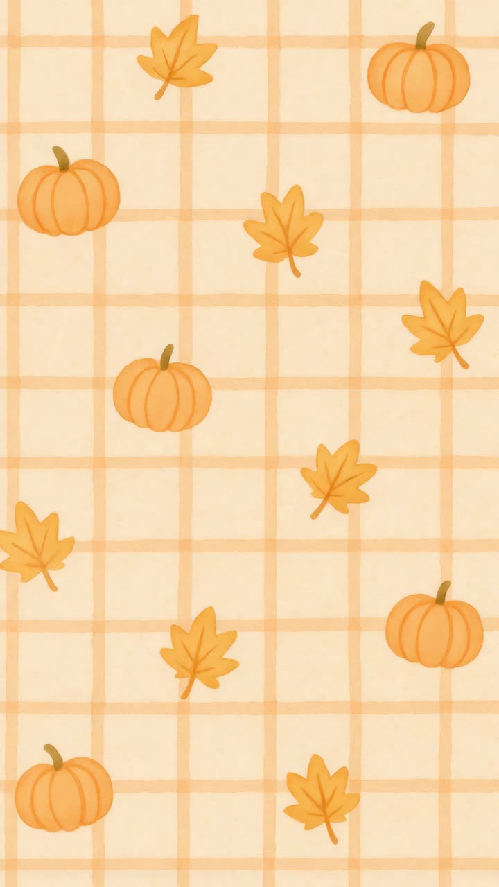 Top-down view of a fall-themed pattern with pumpkins and leaves on a plaid background