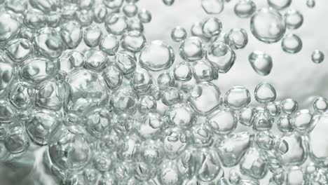 upwards drifting transparent bubbles in low angle on white background