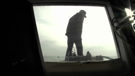 un hombre se para en la cubierta de un barco